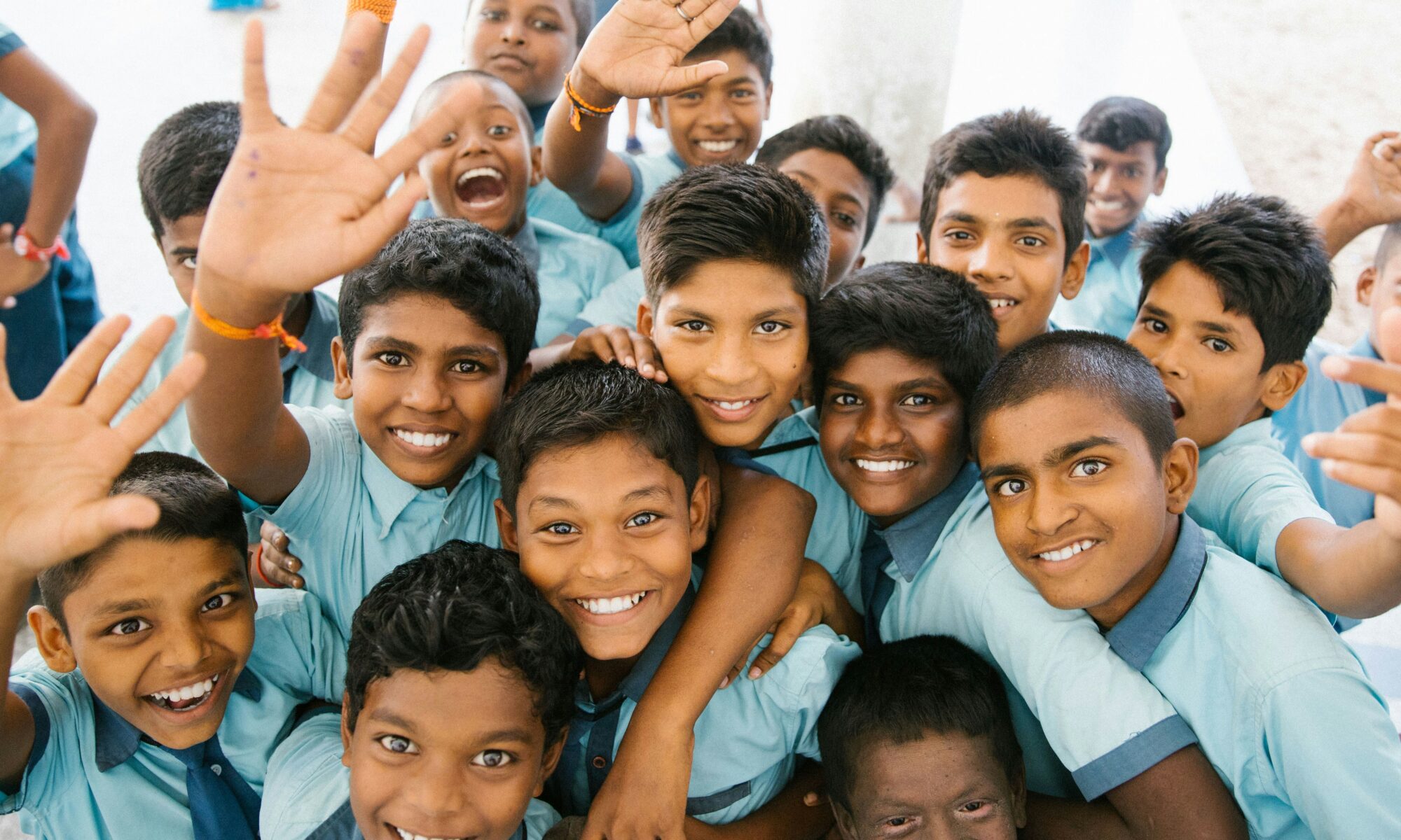 A group of Indian schoolchildren smiling together in their blue uniforms